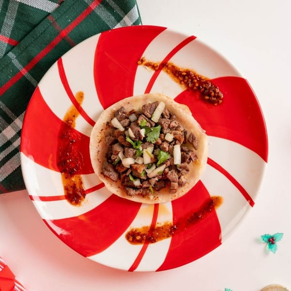 A Santa Madre Taco Shop carne asada taco with onions and cilantro on a candy cane plate.